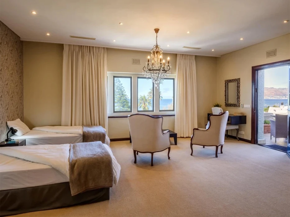 Spacious double room with two beds, armchairs and a sea view.