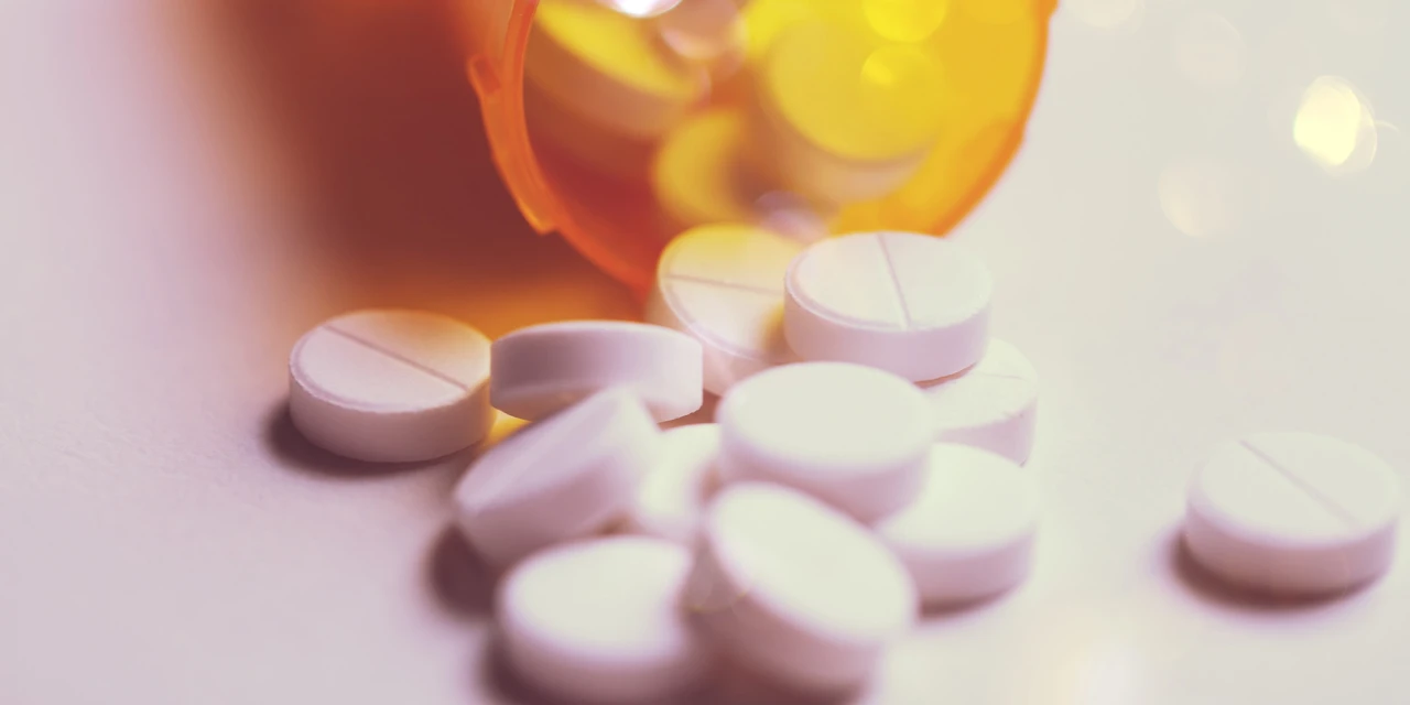 Witte lorazepam tabletten liggen verspreid voor een open oranje pillenfles.