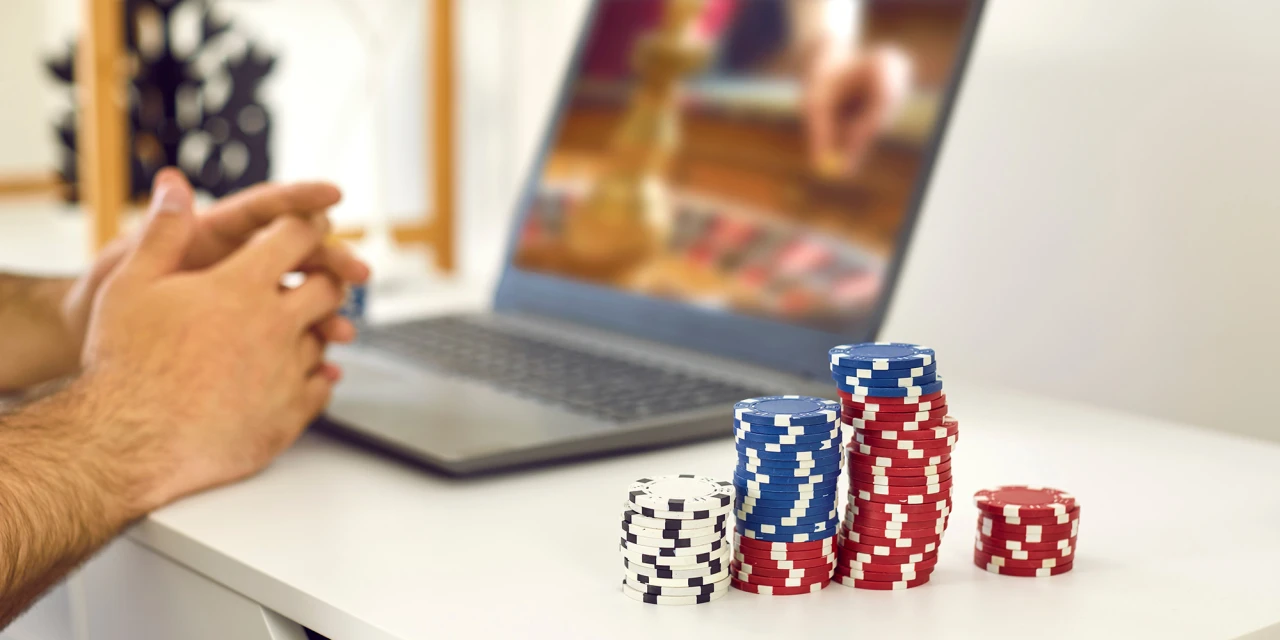 Een persoon heeft hulp bij gokverslaving nodig, terwijl hij online speelt met pokerchips.