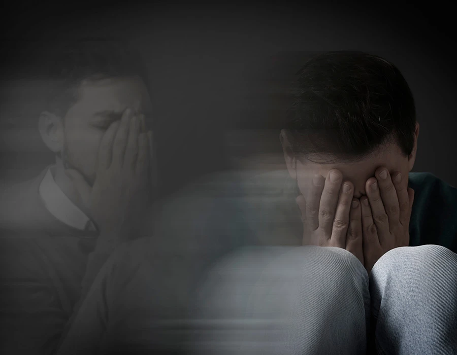 Een man met zijn handen voor zijn gezicht denkt na over wat een overdosis is.