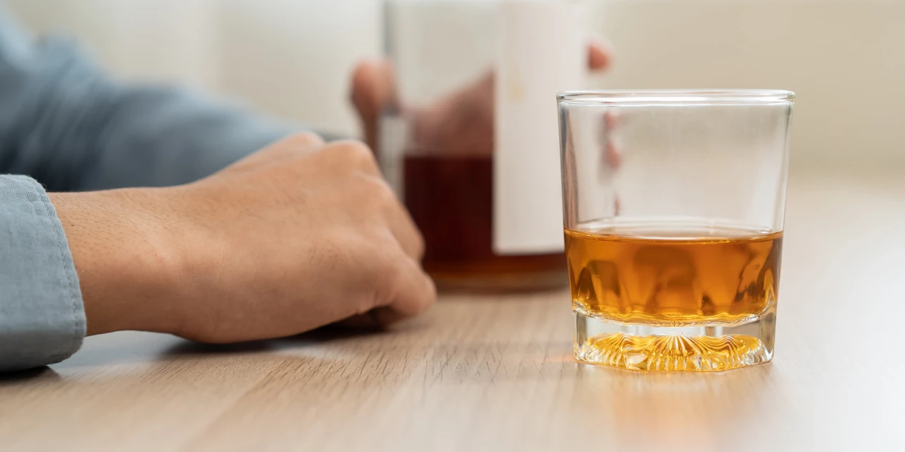 Alcohol detox situatie met glas en fles alcohol verleiding tijdens herstel.