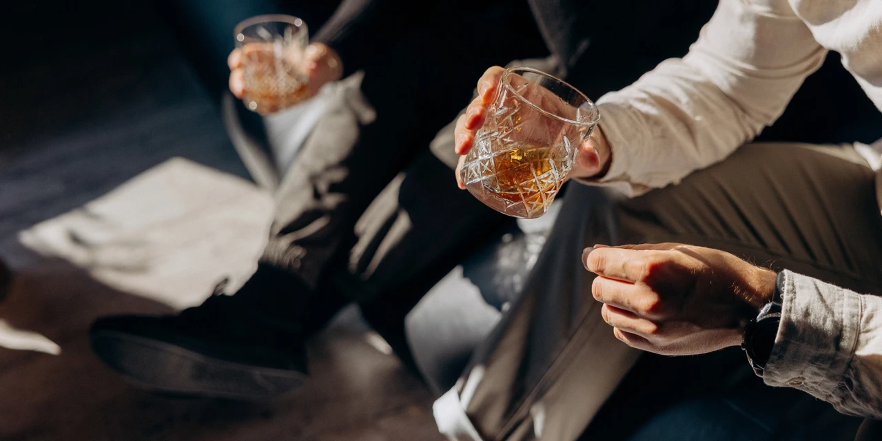 Twee personen met glazen alcohol, situatie die kan leiden tot kwade dronk.