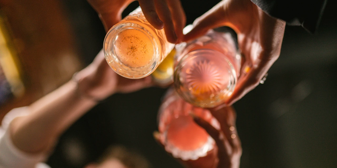 Mensen proosten met glazen alcohol tijdens een feest.