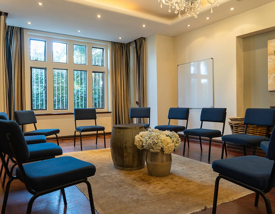 Groepsruimte afkickkliniek Zuid-Afrika met stoelen in kring.