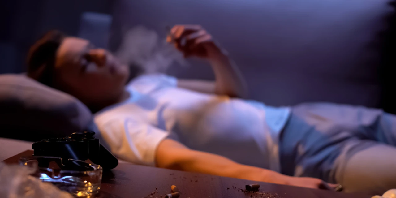 Persoon ligt op bank na roken en denkt aan stoppen met blowen.
