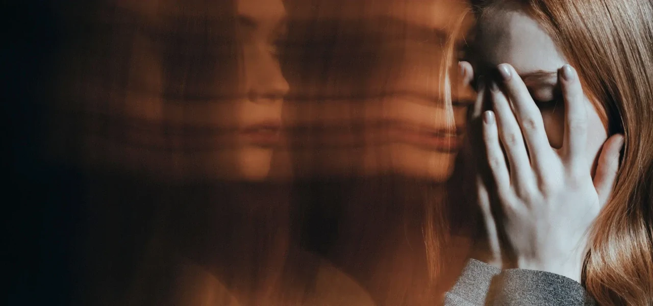 psychose-door-blowen Vrouw met psychose door blowen houdt de handen voor haar gezicht en ziet zichzelf dubbel.