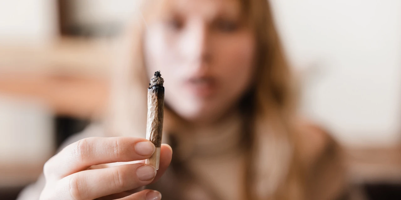 Persoon houdt joint vast toont invloed van stoppen met blowen op je uiterlijk.