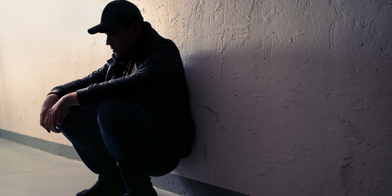 Man zit tegen muur kijkt somber. Hij worstelt met 4-fa 4-fma en 4-fmp-verslaving.