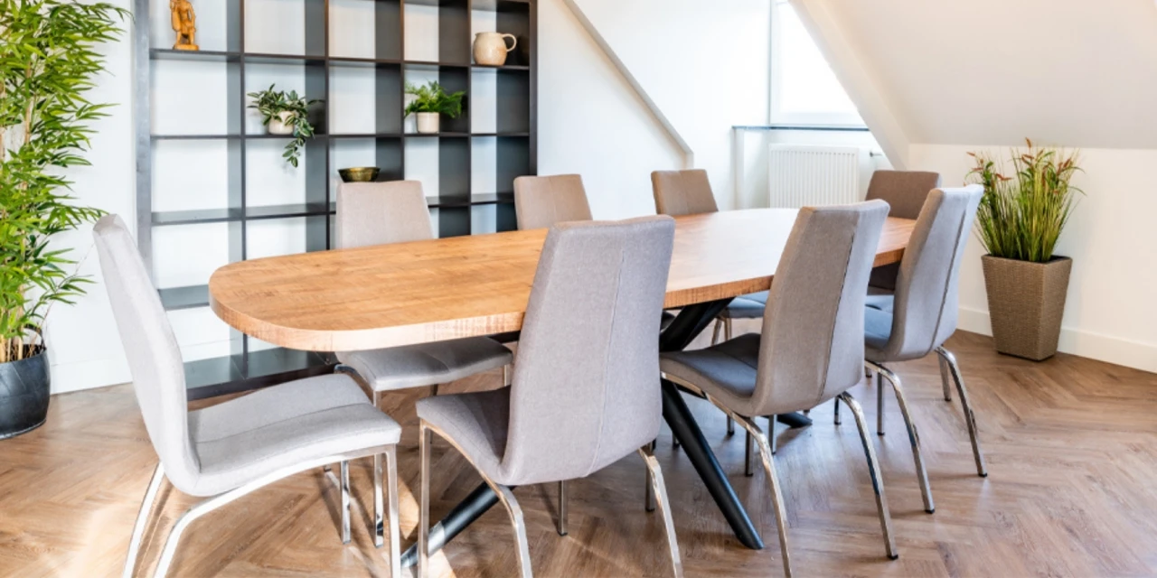 Moderne vergaderruimte met grote tafel, acht stoelen en planten, ideaal voor intakegesprek.