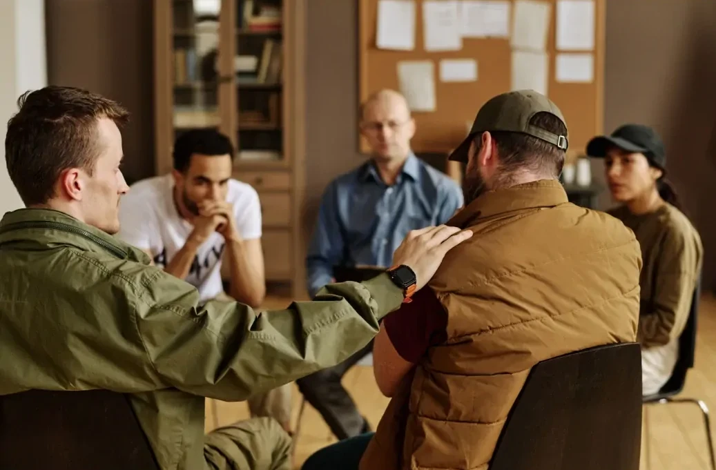 kringgesprek Kringgesprek tussen vijf personen in een lokaal met prikbord.