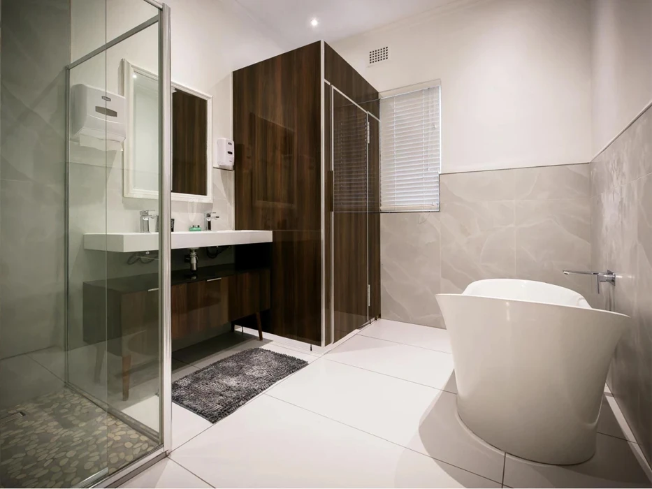 afkickkliniek-zuid-afrika-badkamer Luxe badkamer van afkickkliniek Zuid-Afrika, met een ligbad, douchecabine, wastafel en kast.