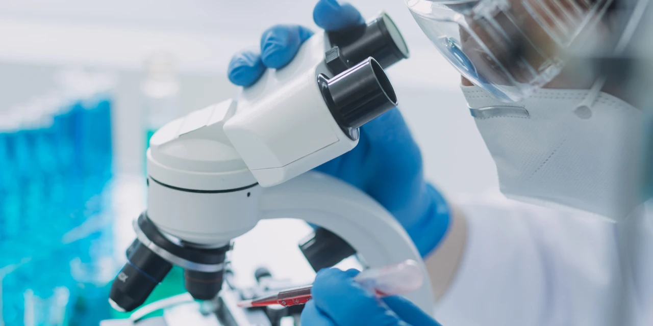 Onderzoek in lab naar alcoholisme en erfelijkheid met microscoop en monster in buisje.