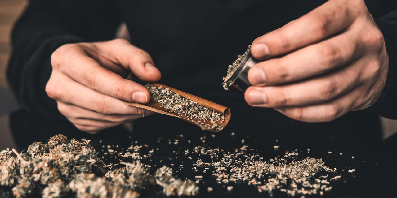 Persoon rolt joint en laat zien hoe cannabisverslaving het dagelijkse leven overneemt.