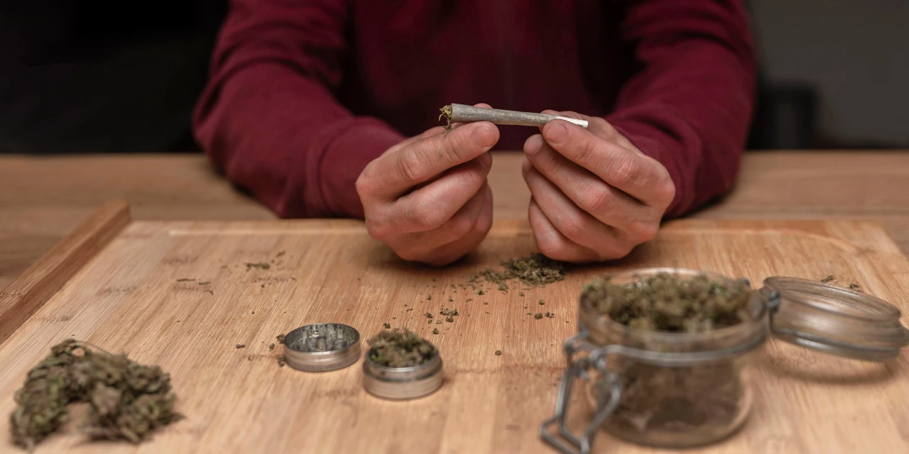 Handen die een joint rollen tonen invloed van stoppen met blowen op je uiterlijk.