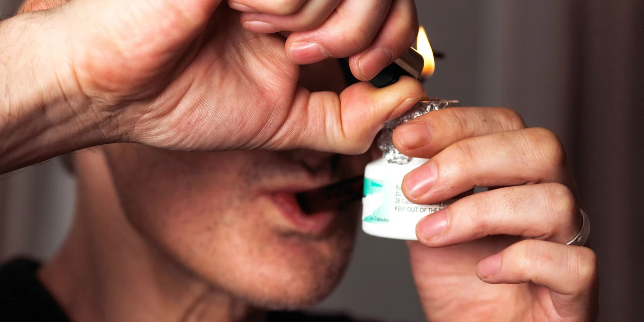 Persoon die cocaïne rookt/ coke based met aansteker en geïmproviseerde pijp dichtbij gezicht.