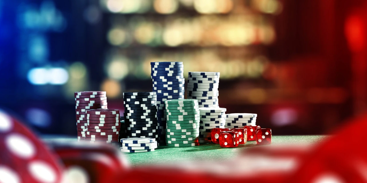 Wat is gokken? Het beeld toont verschillende stapels pokerchips en dobbelstenen.