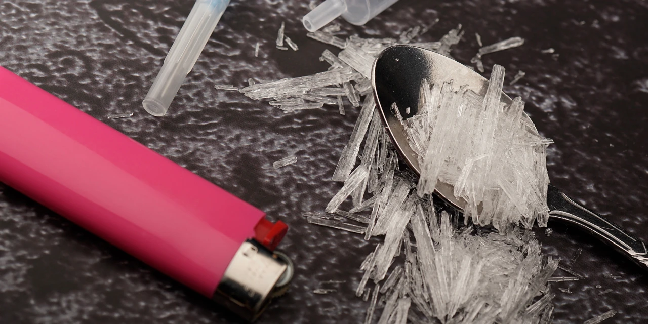 Lepel met kristallen naast aansteker beeld van crystal meth-verslaving.