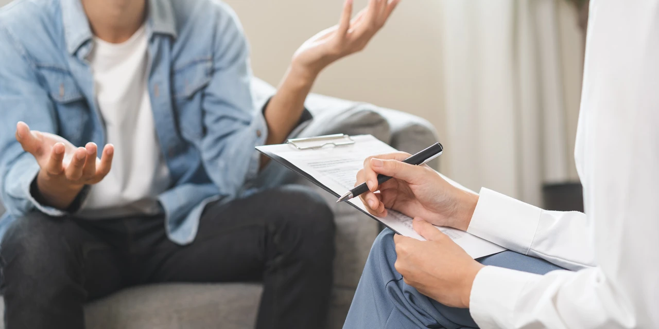 Persoon praat met therapeut tijdens sessie over mentale gezondheid en krijgt hulp.