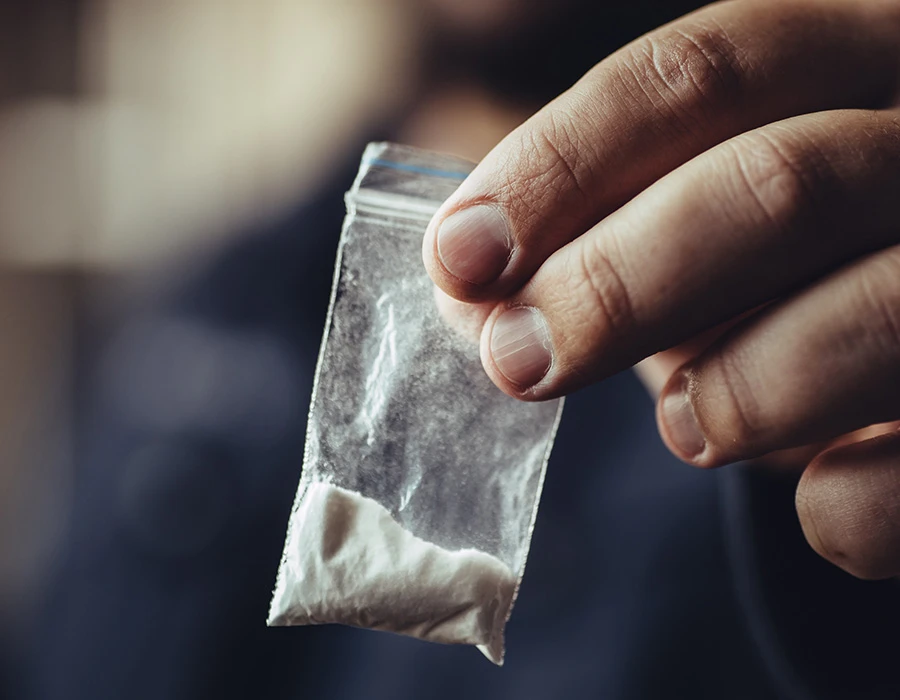 4mmc verslaving zakje met wit poeder in hand als symbool voor gebruik van designerdrugs.