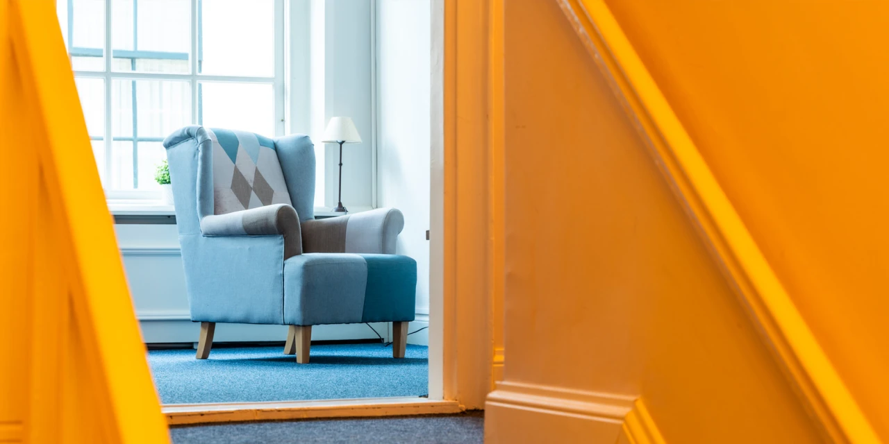 Comfortabele stoel in rustige ruimte met daglicht.