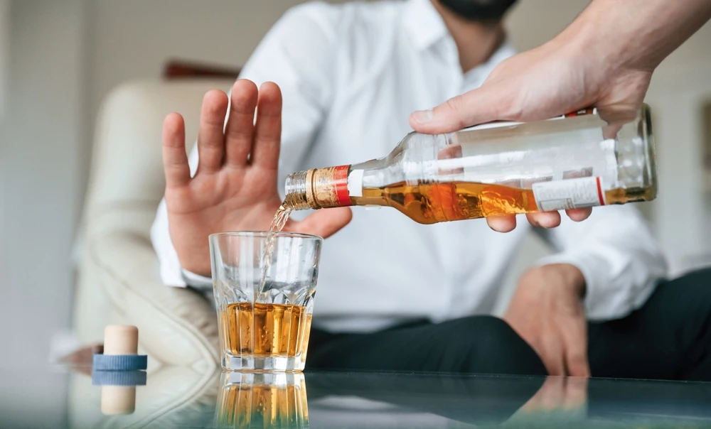Een man weigert alcohol terwijl het wordt ingeschonken. Waarom is alcohol slecht voor je?