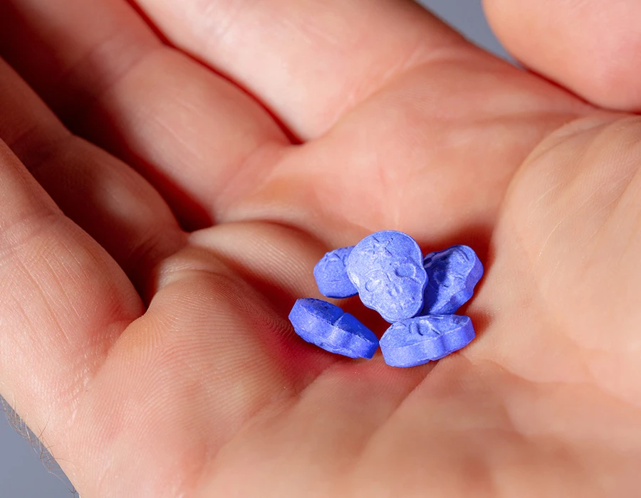  Blauwe 2C-B-pillen in een hand.