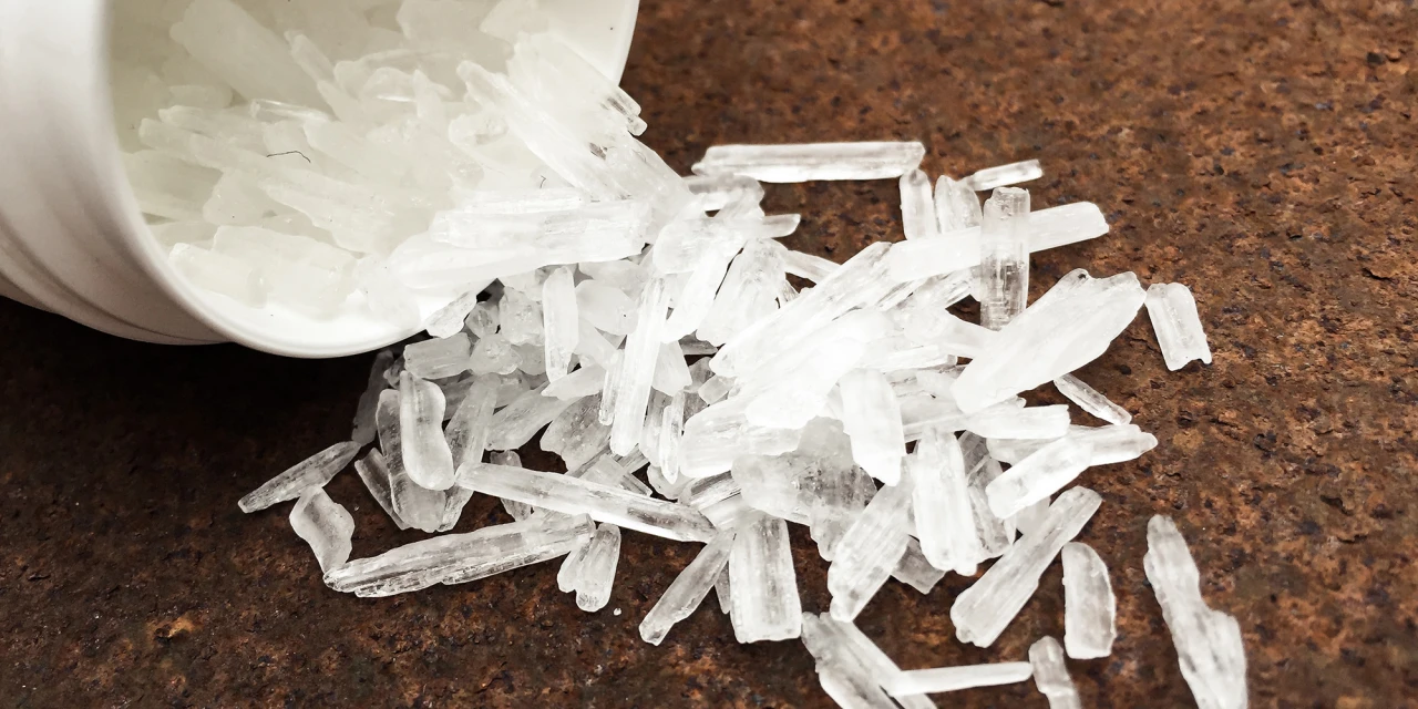 Close-up van witte kristallen op tafel symbool voor crystal meth-verslaving.