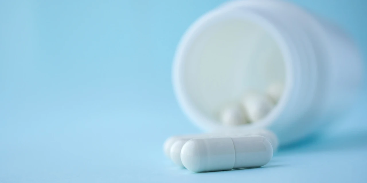 Open potje dexamfetamine met witte capsules.