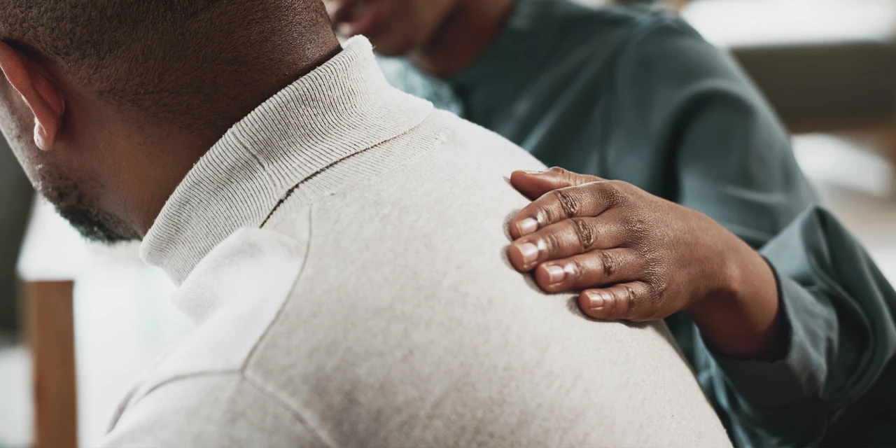 Ondersteunende hand op schouder als symbool voor mentale gezondheid en zorg.