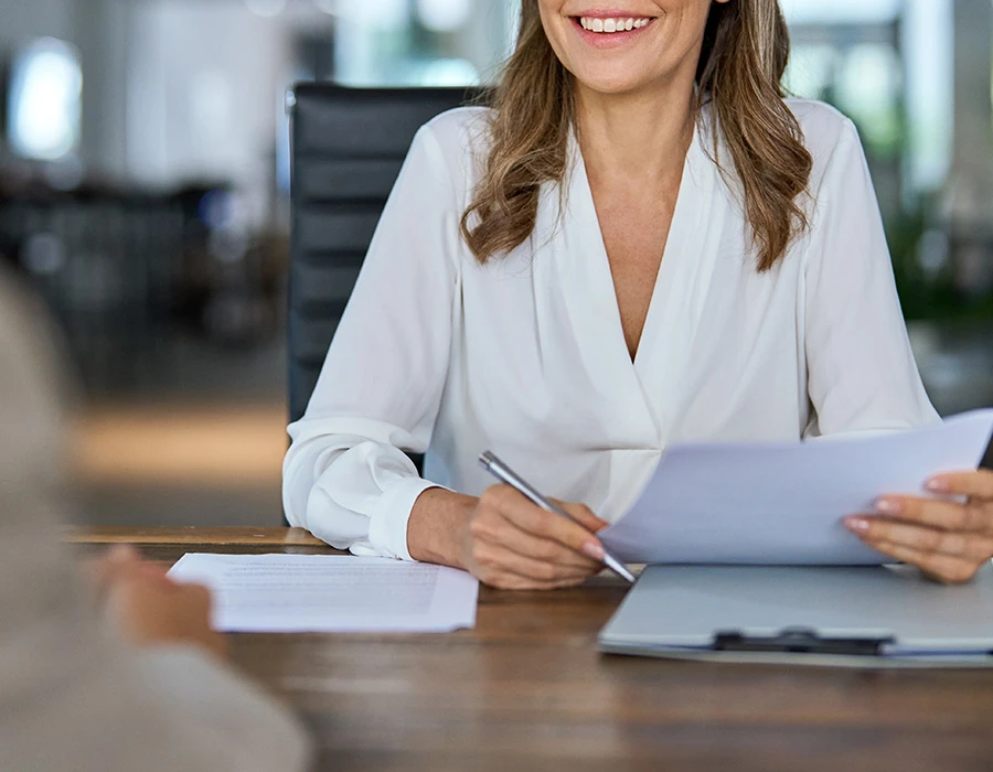 Senior HR-medewerker bespreekt documenten tijdens gesprek met medewerker