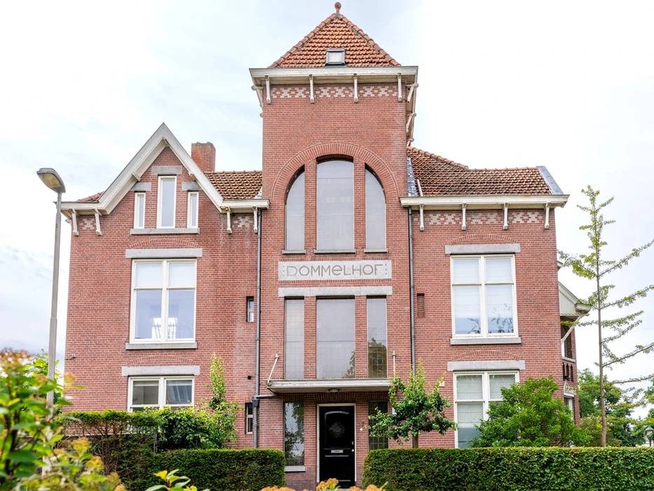 afkickkliniek-fazantlaan-buitenaanzicht Voorkant van poliklinische verslavingszorg Eindhoven, een monumentaal pand met Dommelhof op de muur.