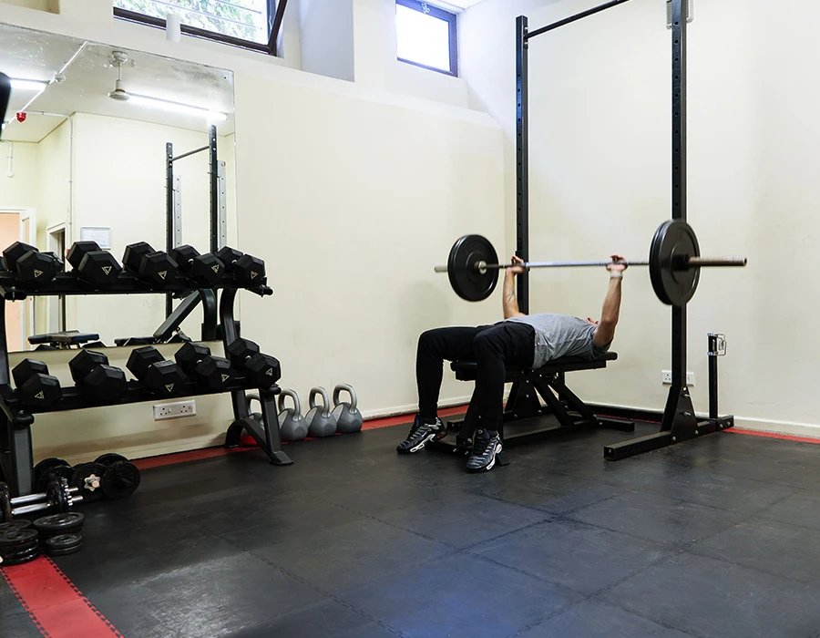 Sportruimte van afkickkliniek Zuid-Afrika met fitnessapparatuur en gewichten.