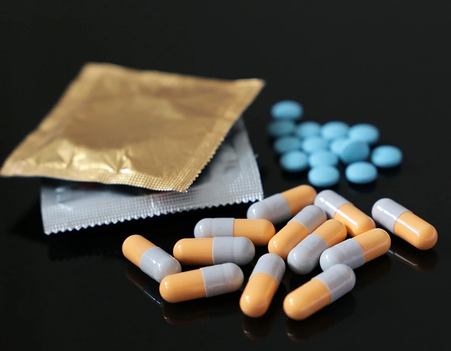 Wapdate met oranje-witte capsules, blauwe tabletten en gouden en zilveren blisterverpakkingen.