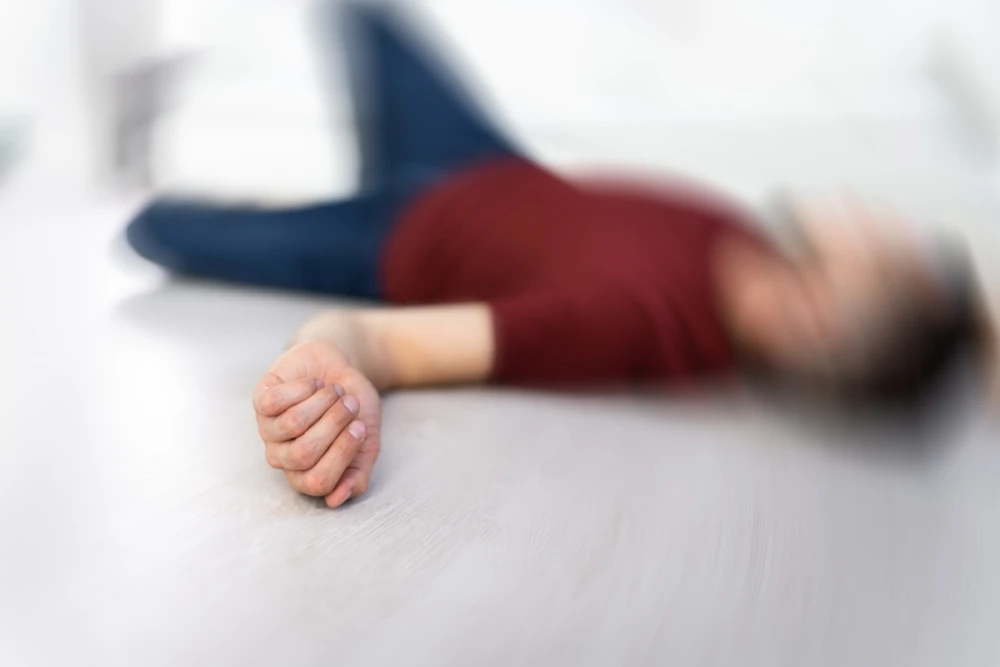 Bewusteloos persoon op de vloer, ter illustratie van een opioïdenoverdosis waarbij Narcan helpt.