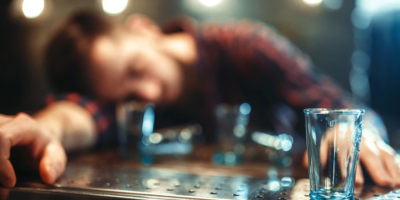 Dronken man aan bar laat zien hoe lang alcohol in je bloed blijft.