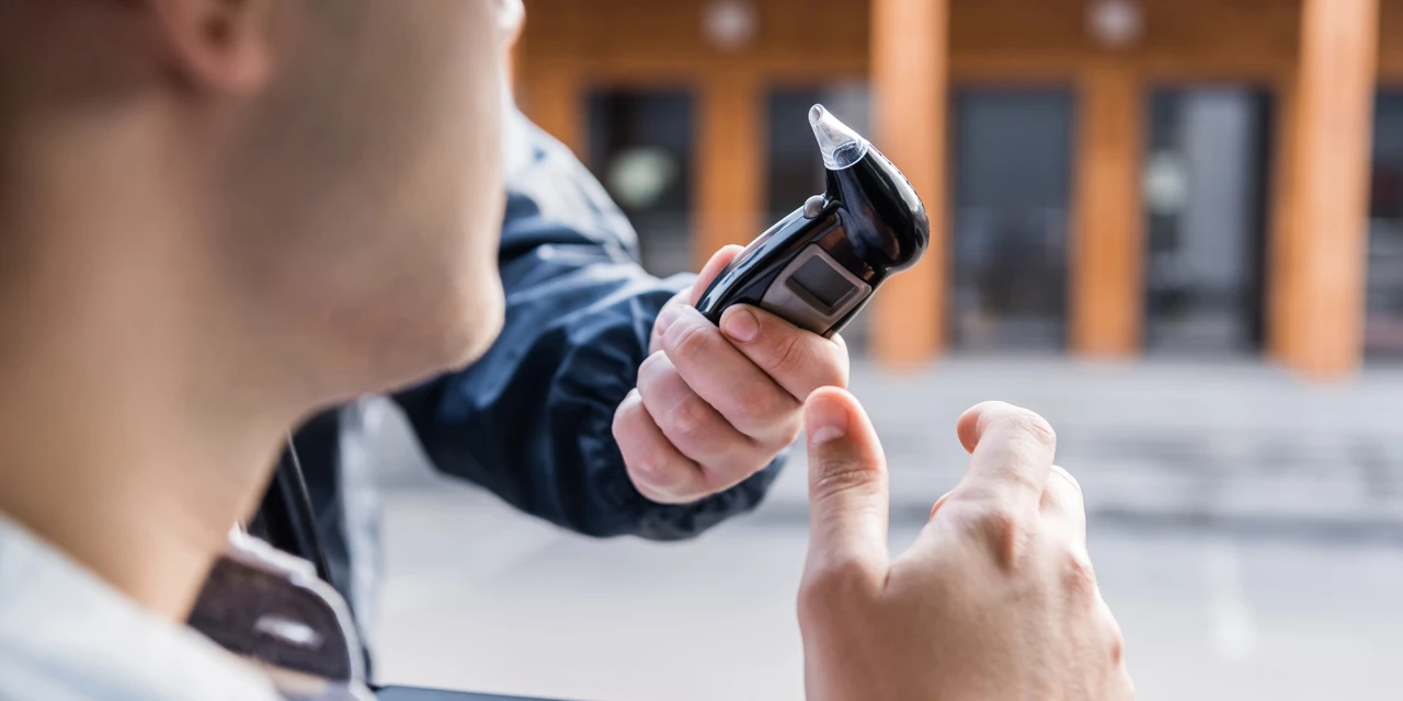 Persoon krijgt blaastest voor controle van alcoholpromillage in de auto.