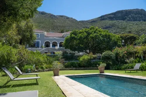 zuid-afrika-zwembad-zijaanzicht Tuin met ligbedden en een zwembad, met op de achtergrond de afkickkliniek Zuid-Afrika.