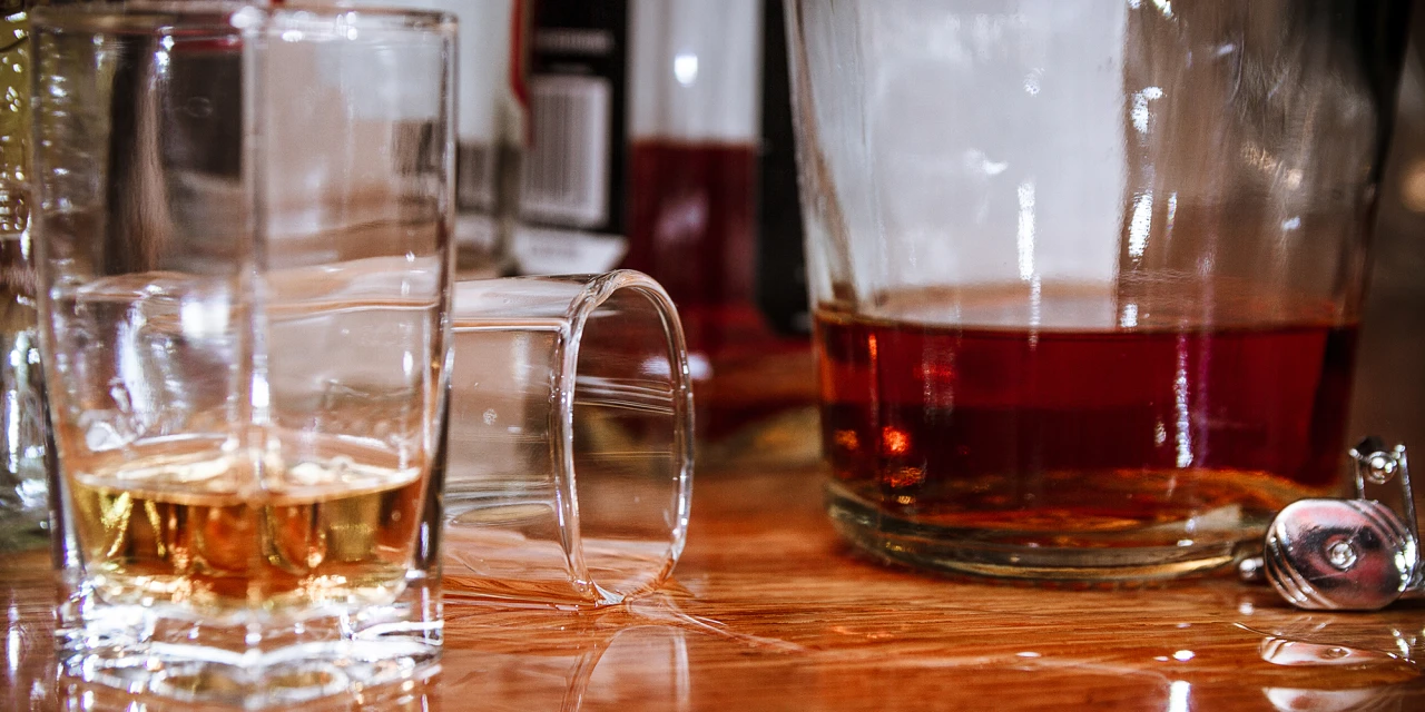 Omgevallen glas alcohol is gevallen op tafel. 