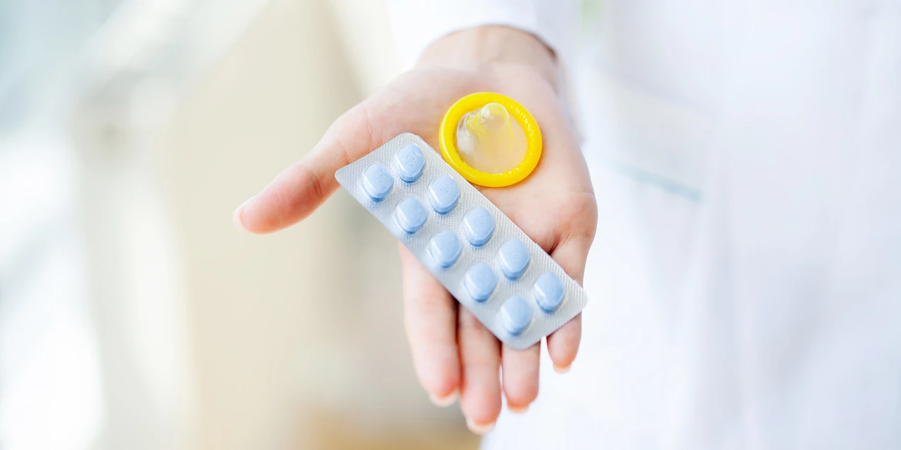 Hand met kamagra pillen en condoom, gebruik van erectiemiddel.