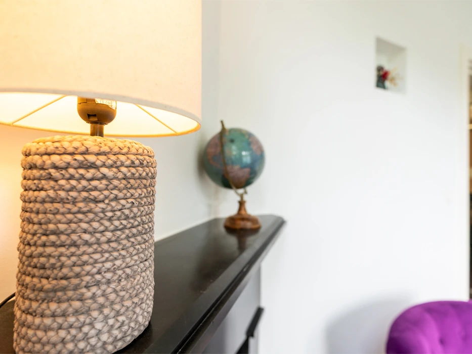 afkickkliniek-fazantlaan-lamp Therapieruimte van poliklinische verslavingszorg Eindhoven, met schouw, een lamp en wereldbol.