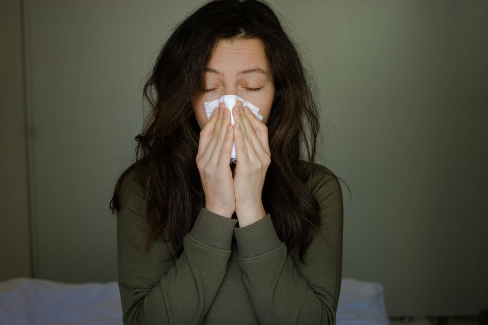 De vloeistof uit een flesje poppers wordt op een doek gedruppeld, waarna de vrouw de damp opsnuift.