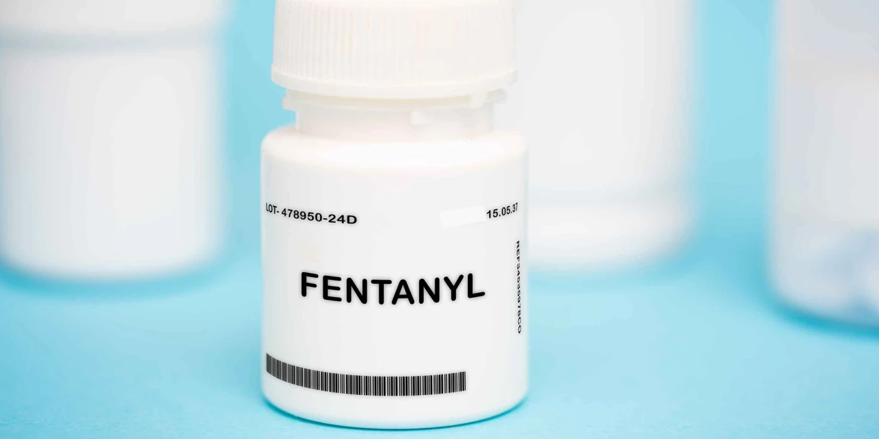 Wit potje met fentanyl label op blauwe achtergrond in close-up.