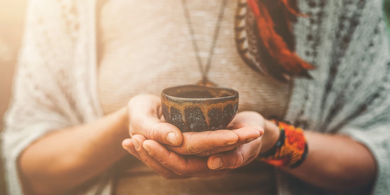 Persoon houdt kom vast tijdens ayahuasca ceremonie.