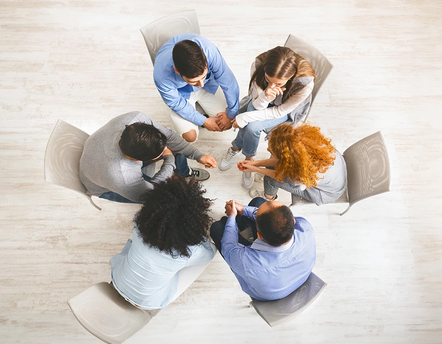 Groep mensen in kring tijdens gesprek in 12 stappen programma.