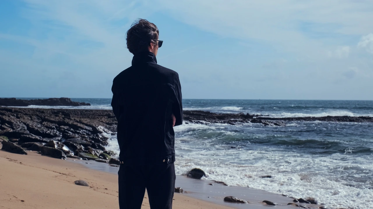 Man staat op het strand en kijkt naar de oceaan terwijl hij nadenkt over een behandeling van zijn cocaïneverslaving. 