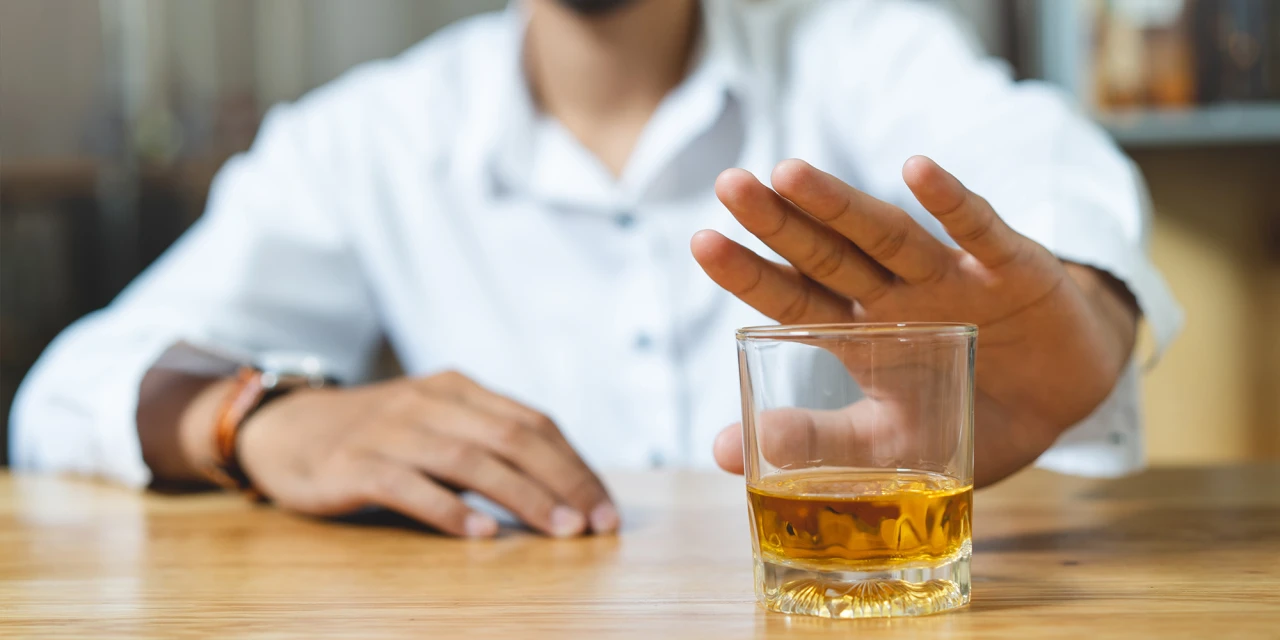 Tijdens afkicken alcohol weigert man een glas whisky.