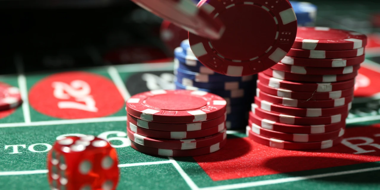Fiches op een roulette tafel terwijl iemand nadenkt over stoppen met gokken.