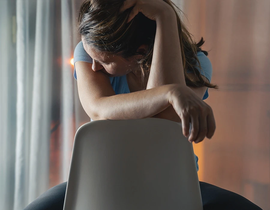 Vrouw kijkt uit het raam en is verdrietig en heeft veel emoties. 