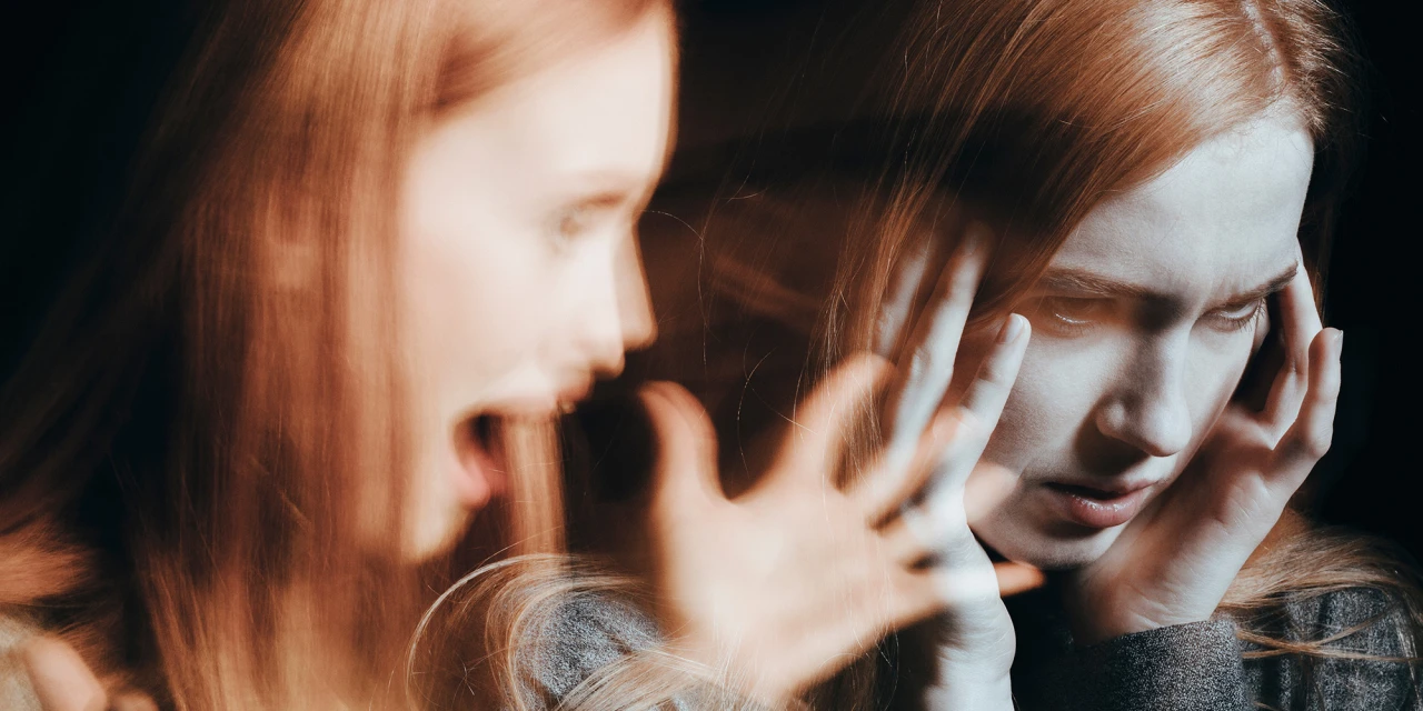 Vrouw met angstige blik en handen bij hoofd toont verband tussen blowen en psychoses.