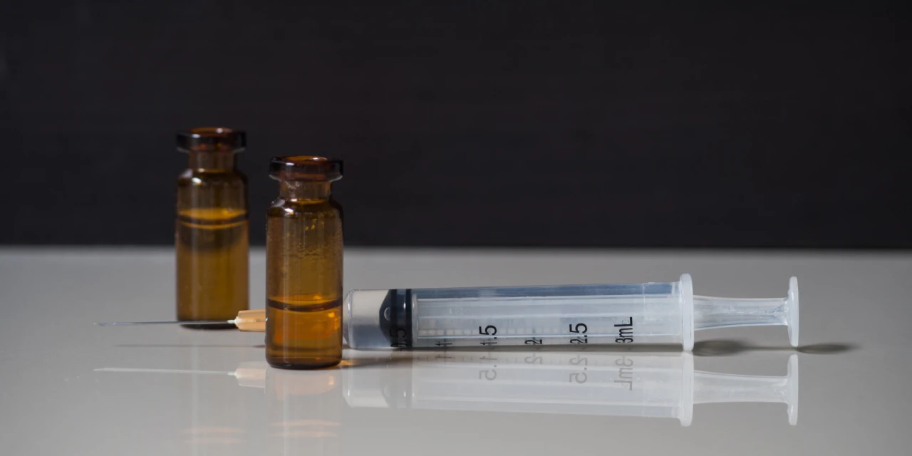 Spuit en bruine ampullen met vloeistof gebruikt bij ketamineverslaving.
